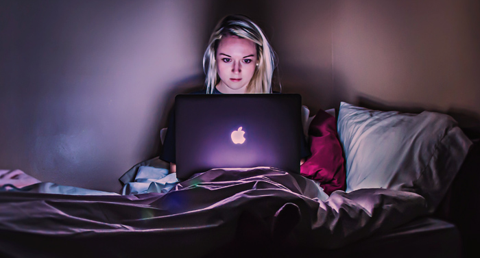 Mädchen arbeitet nachts am Laptop