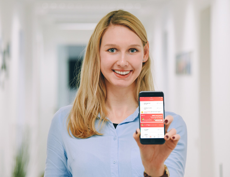 Mitarbeiterin hält Handy mit scoolio in die Kamera